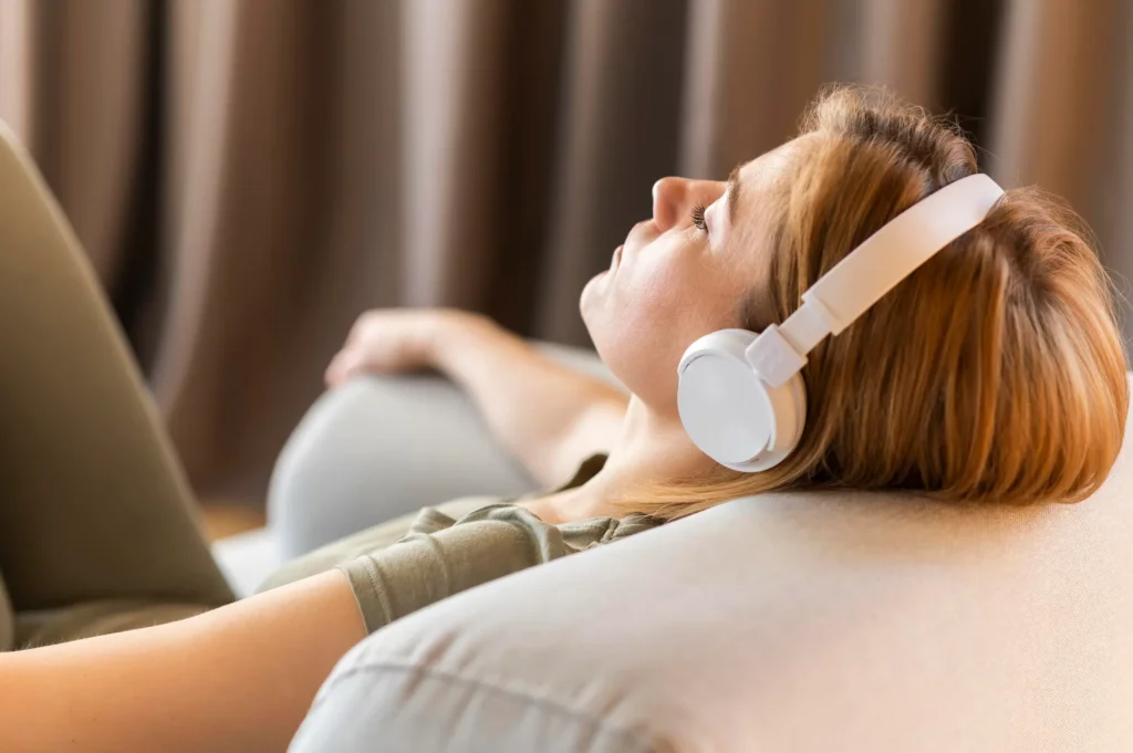 Une femme se relaxe en faisant une session de sophrologie au casque